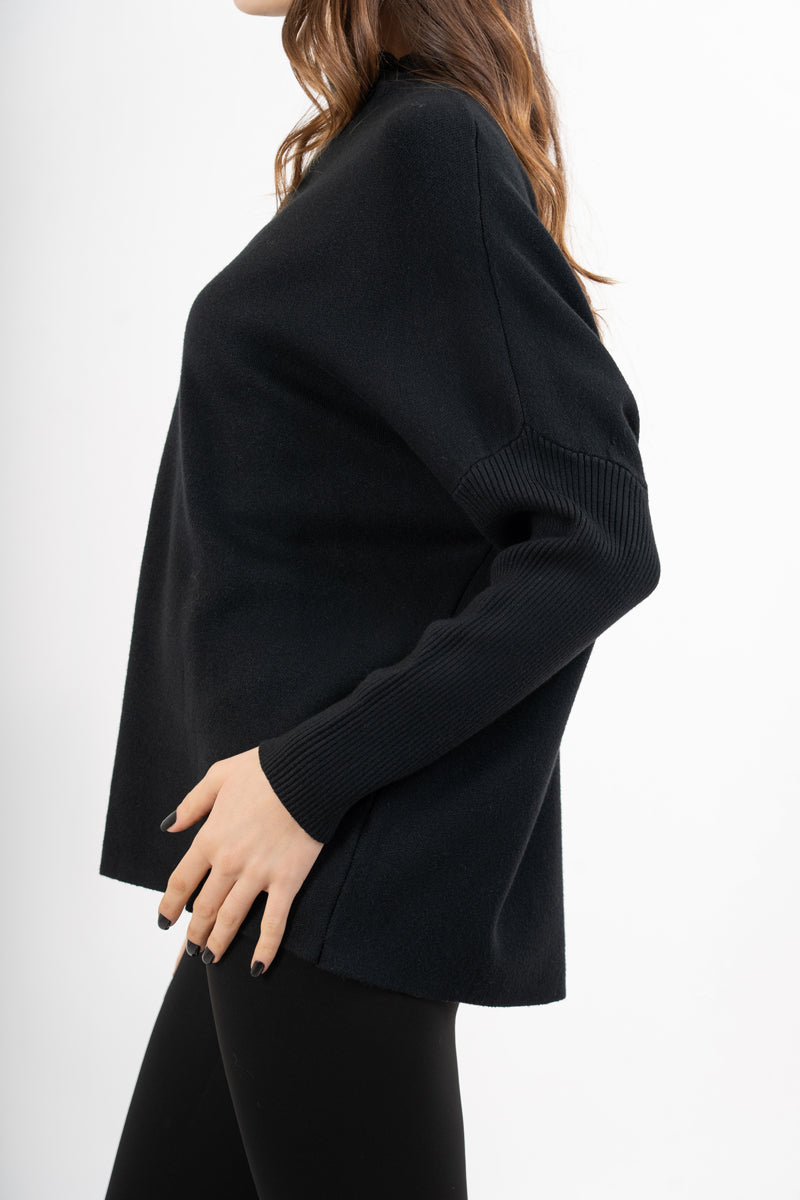 modella indossando Maglia over corta in filato caldo con maniche a costine e collo alto colore