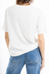modella indossando T-shirt scritta “Meno male che siete perfette voi” colore