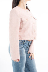 modella indossando Giacchina corta strutturata effetto tweed rosa con bottoni gioiello colore