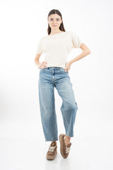modella indossando Jeans balloon in denim elasticizzato con fondo taglio vivo colore