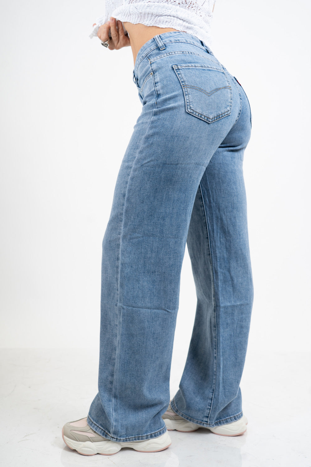 Jeans palazzo a vita bassa in denim lavaggio medio con gamba ampia.