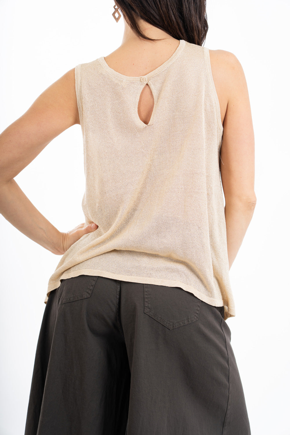 modella indossando Top smanicato in viscosa lurex leggero e semitrasparente, linea svasata e vestibilità morbida. Perfetto per look casual o eleganti. colore