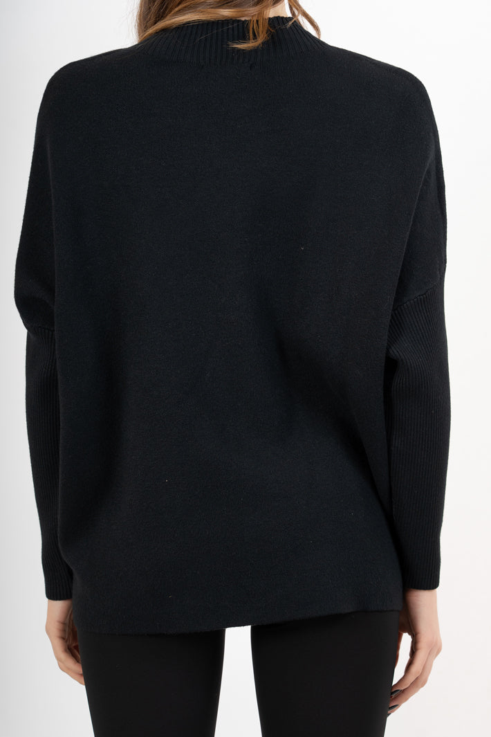 modella indossando Maglia over corta in filato caldo con maniche a costine e collo alto colore