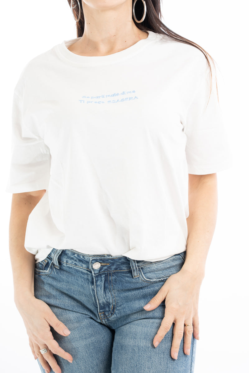 modella indossando T-shirt scritta “Se parli male di me ti prego esagera” colore Bianco-celeste Unica