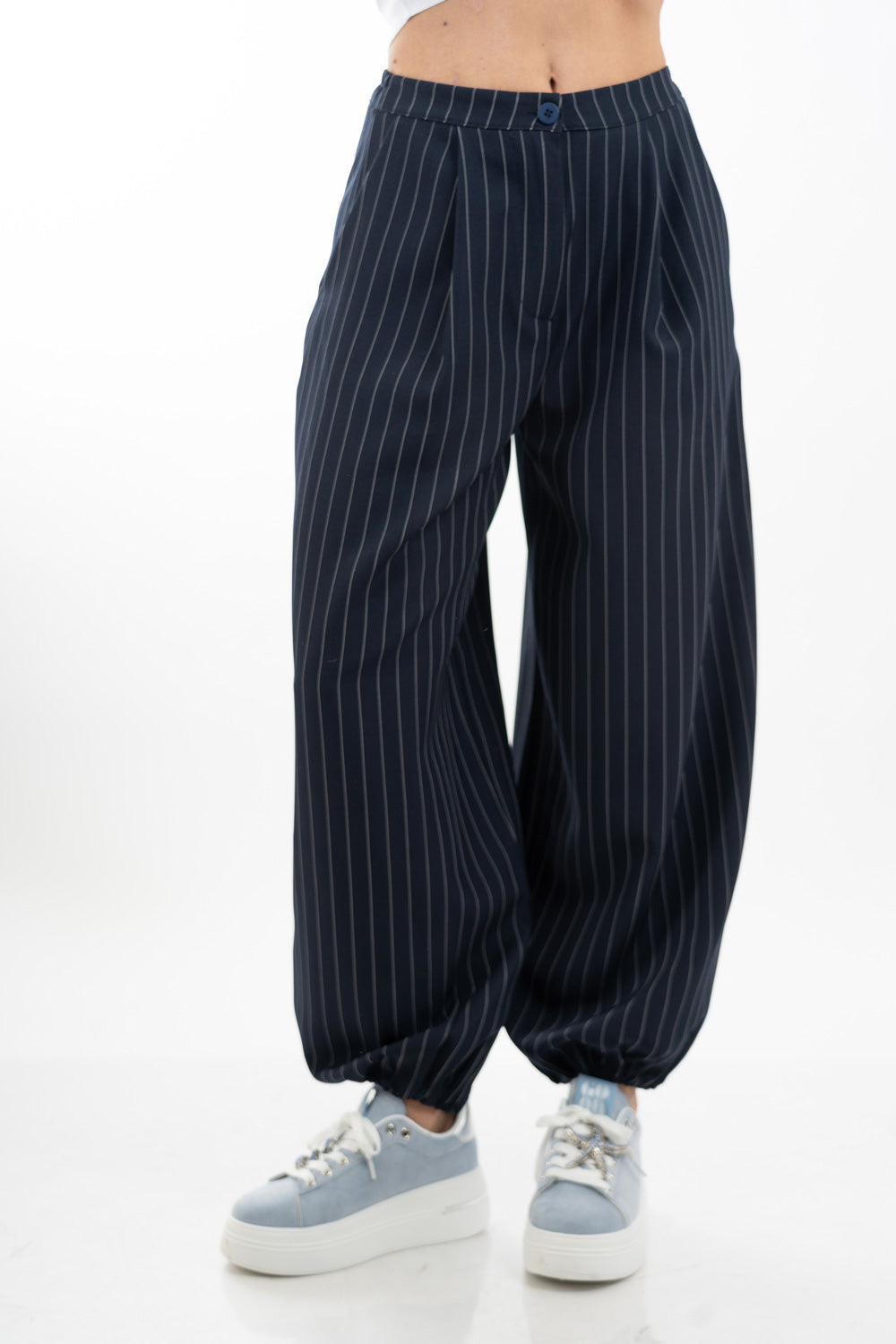 modella indossando Pantalone carrot gessato con pinces e fondo elasticizzato colore Blu Unica