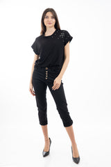 modella indossando Pantalone modello chinos in cotone elasticizzato colore nero con bottoni gioiello a cuore colore