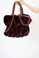 modella indossando Borsa in pelliccia ecologica con manico intrecciato e tracolla a catena colore BORDEAUX Unica
