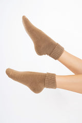 modella indossando Calze corte “Carezza” in filato morbido con bordo risvoltato colore Camel Unica