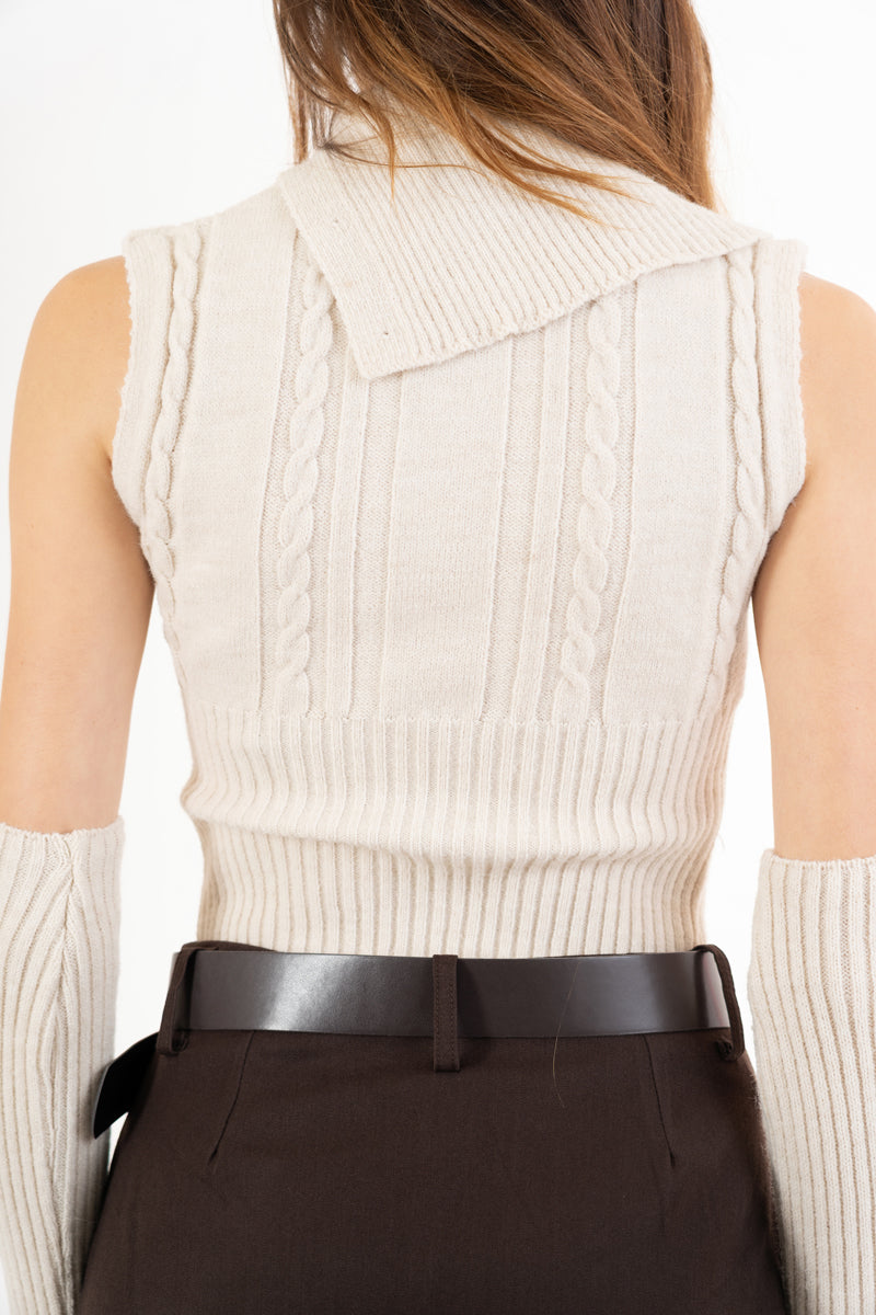 modella indossando Maglia smanicata a trecce con collo alto e bottoni laterali colore