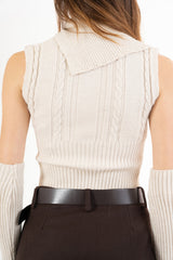 modella indossando Maglia smanicata a trecce con collo alto e bottoni laterali colore