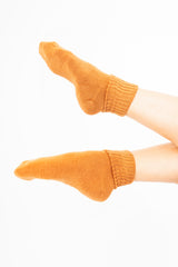 modella indossando Calze corte “Carezza” in filato morbido con bordo risvoltato colore Coccio Unica