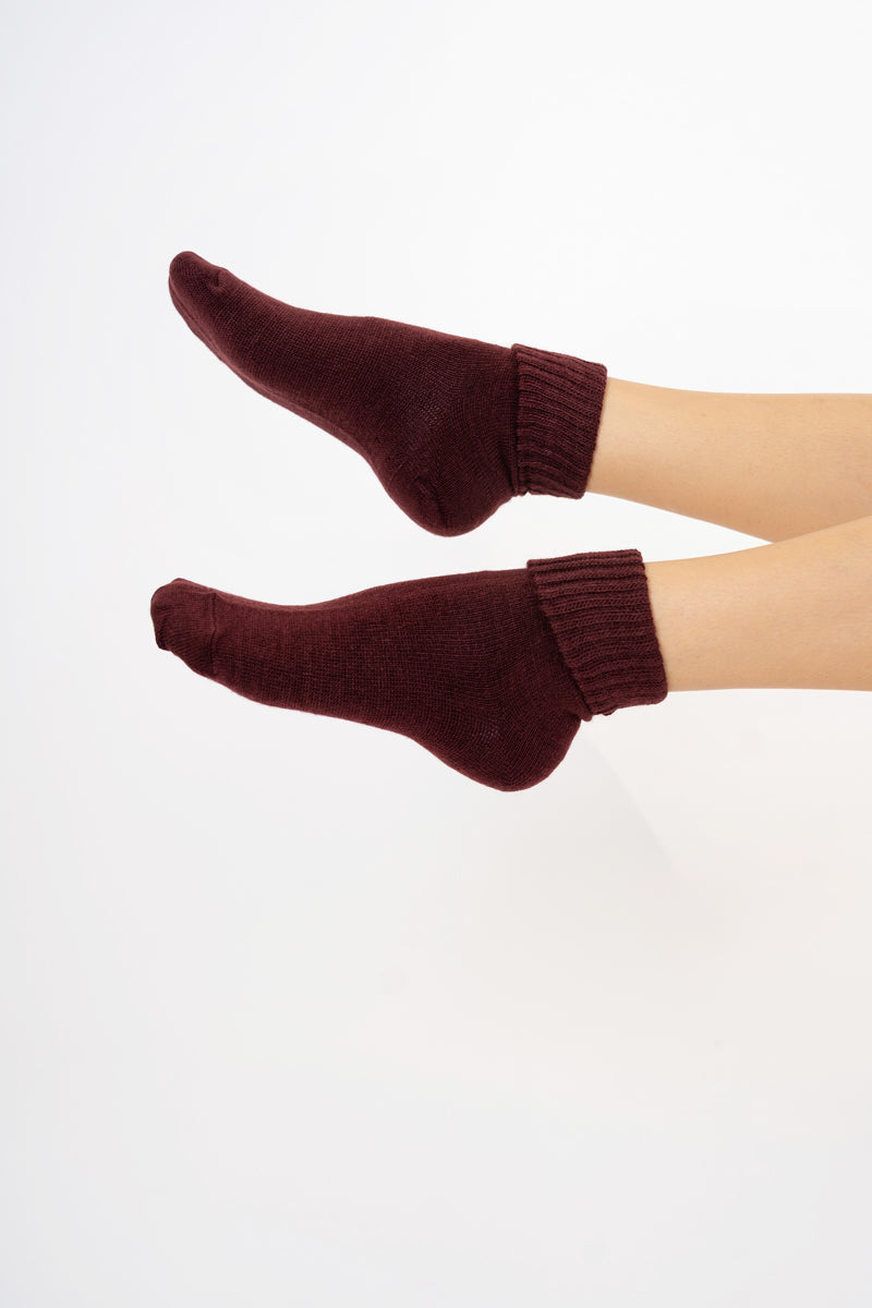 modella indossando Calze corte “Carezza” in filato morbido con bordo risvoltato colore BORDEAUX Unica