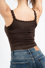 modella indossando Top in maglina elasticizzata con pizzo e bottoni decorativi colore
