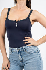 Top in maglina elasticizzata con pizzo e bottoni decorativi.