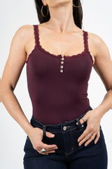 modella indossando Top in maglina elasticizzata con pizzo e bottoni decorativi colore Prugna Unica