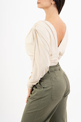 modella indossando Maglia crop drappeggiata con doppio scollo incrociato e spalle strutturate colore