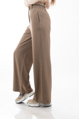 modella indossando Pantalone palazzo con elastico sul retro e tasche laterali a scomparsa colore Fango