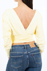 modella indossando Maglia crop drappeggiata con doppio scollo incrociato e spalle strutturate colore