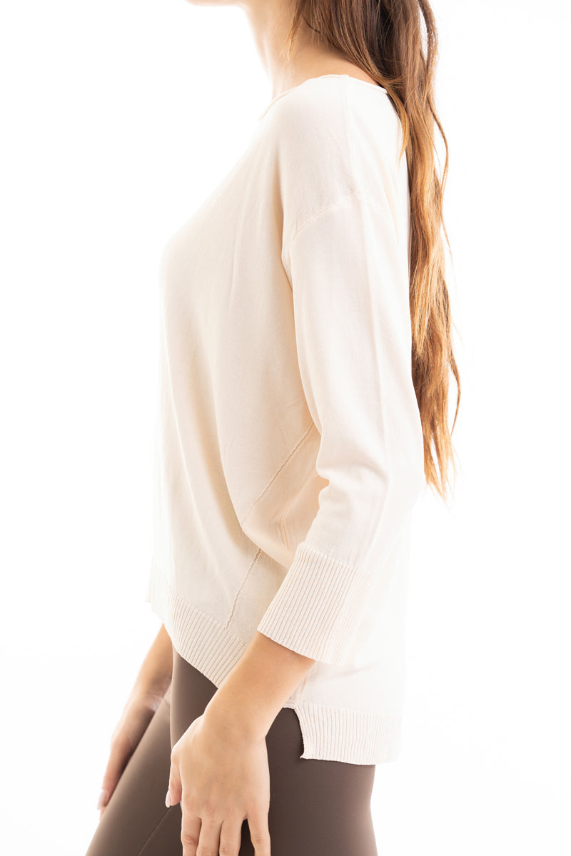 modella indossando Maglia ampia corta davanti e più lunga dietro in filato leggero colore Beige Unica