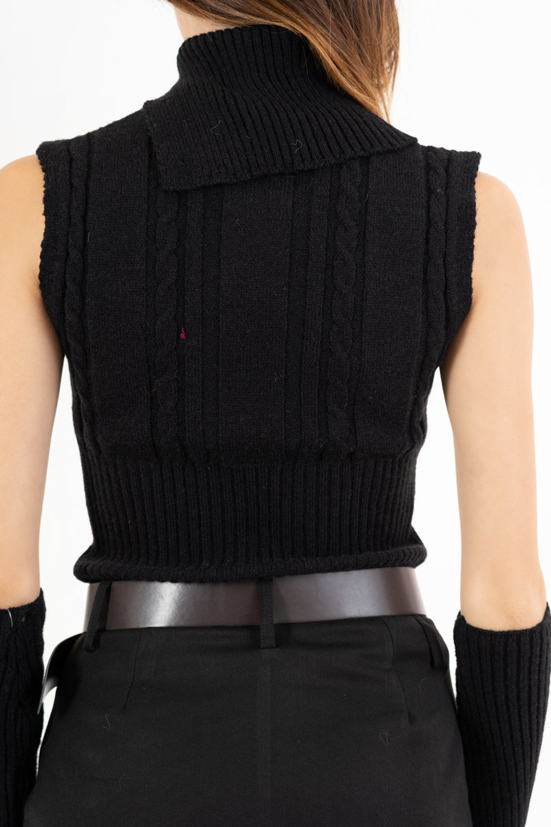 modella indossando Maglia smanicata a trecce con collo alto e bottoni laterali colore