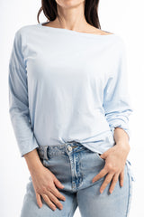 modella indossando Maglia over in cotone elasticizzato con scollo ampio e spacchi laterali colore Celeste Unica