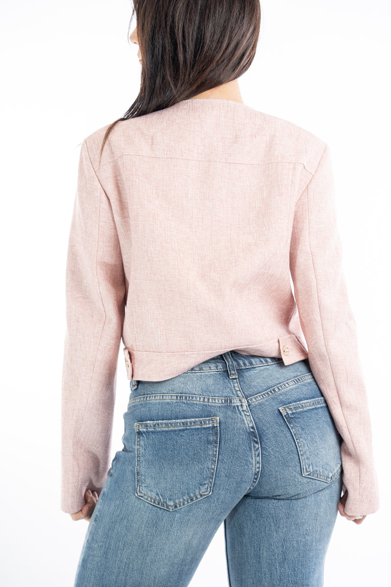 modella indossando Giacchina corta strutturata effetto tweed rosa con bottoni gioiello colore