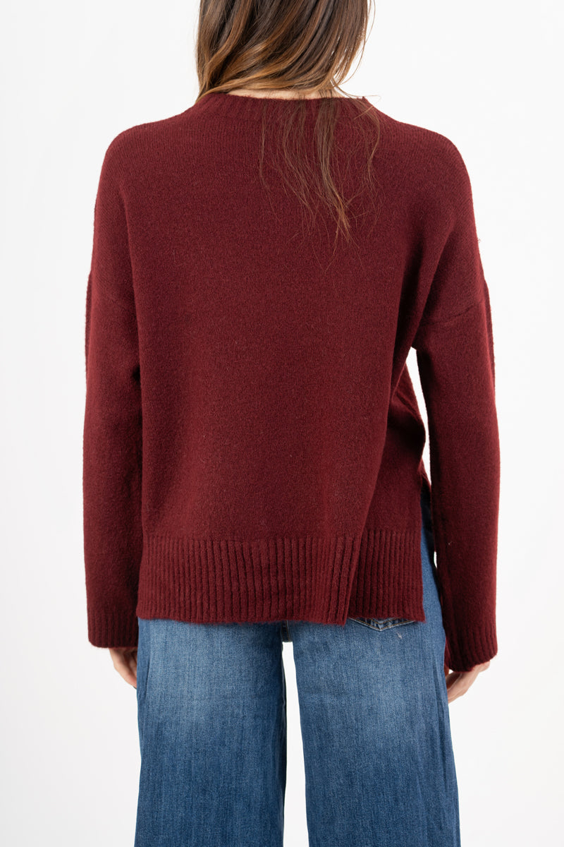 modella indossando Maglione over girocollo con fondo asimmetrico e spacchi laterali colore