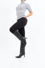 modella indossando Stivali alti in ecopelle nera con tacco 6cm e punta affusolata colore