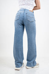 Jeans palazzo a vita bassa in denim lavaggio medio con gamba ampia.