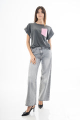 modella indossando Jeans wide leg grigio slavato con tasca posteriore rosa strass e rotture colore
