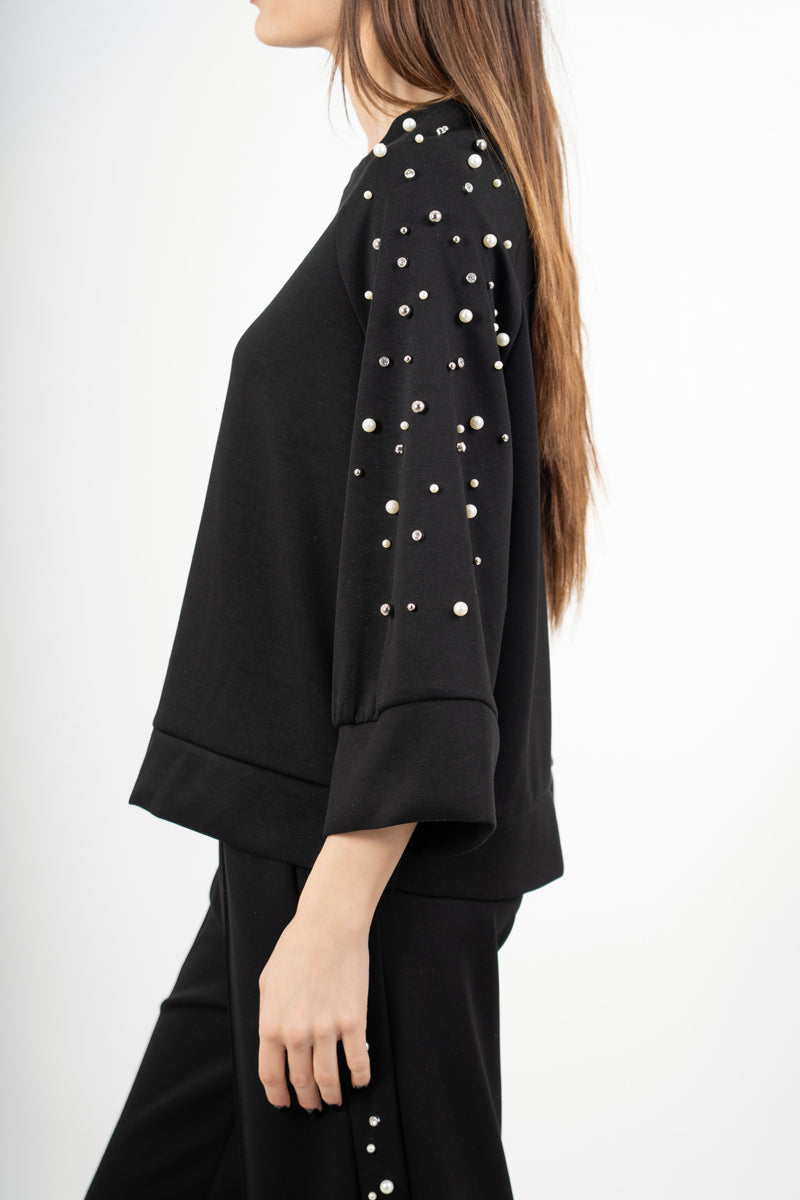 modella indossando Completo tuta con applicazioni gioiello e pantalone palazzo colore