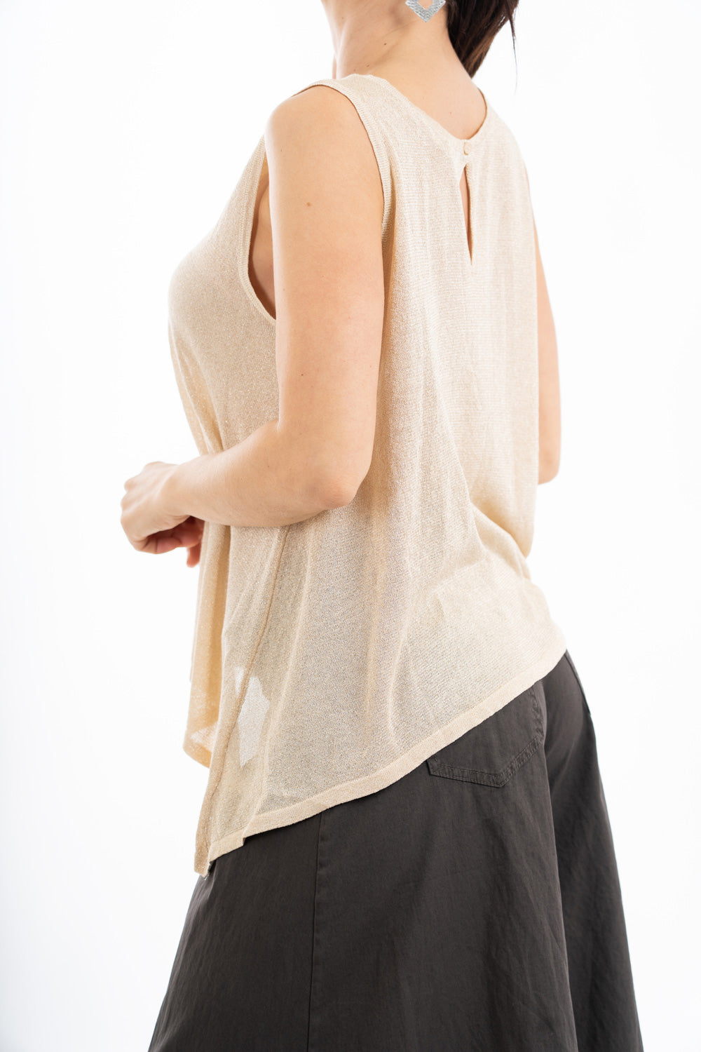 modella indossando Top smanicato in viscosa lurex leggero e semitrasparente, linea svasata e vestibilità morbida. Perfetto per look casual o eleganti. colore