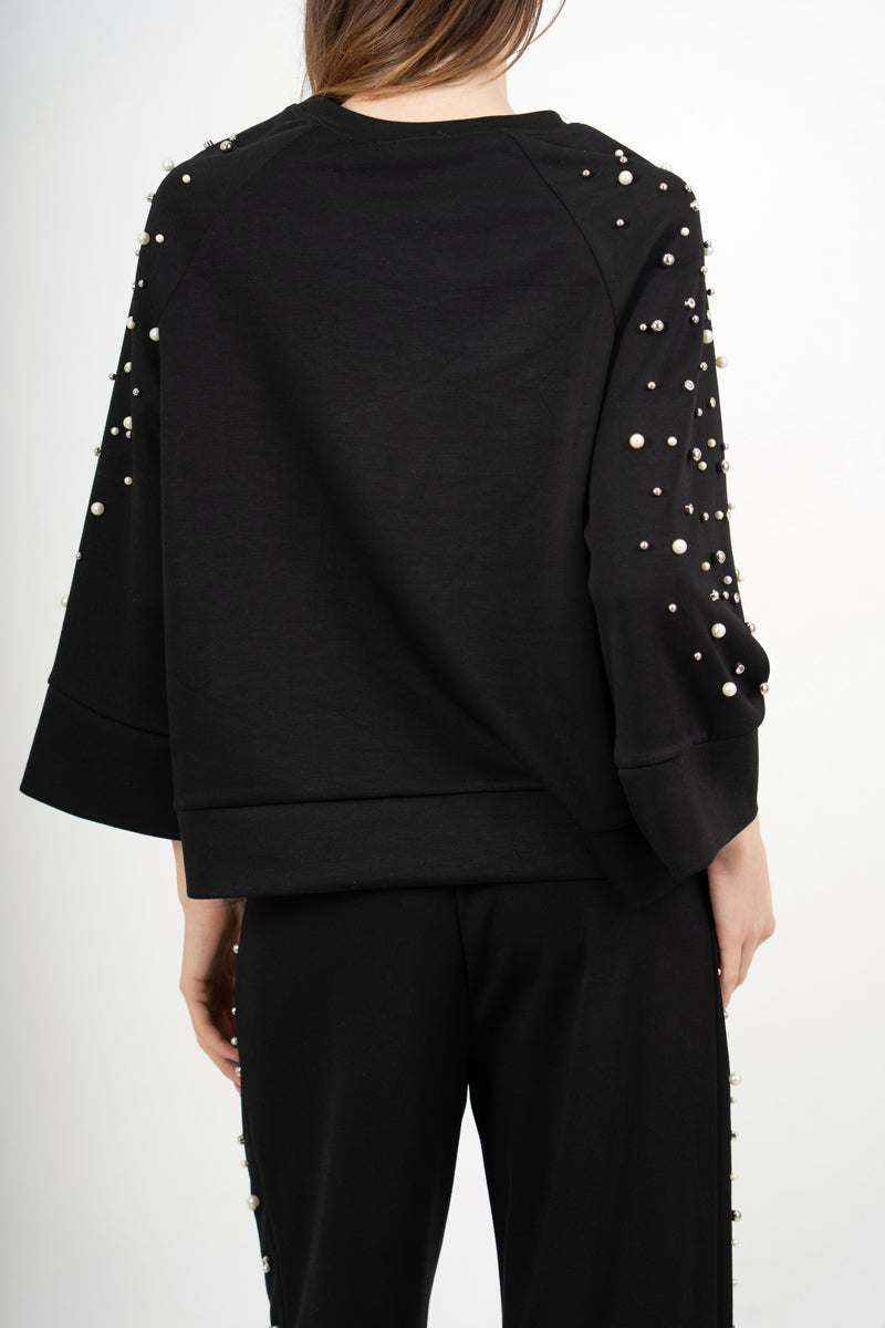 modella indossando Completo tuta con applicazioni gioiello e pantalone palazzo colore