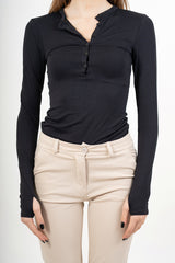 modella indossando Maglia serafino in maglina elasticizzata con foro per il pollice colore Nero Unica