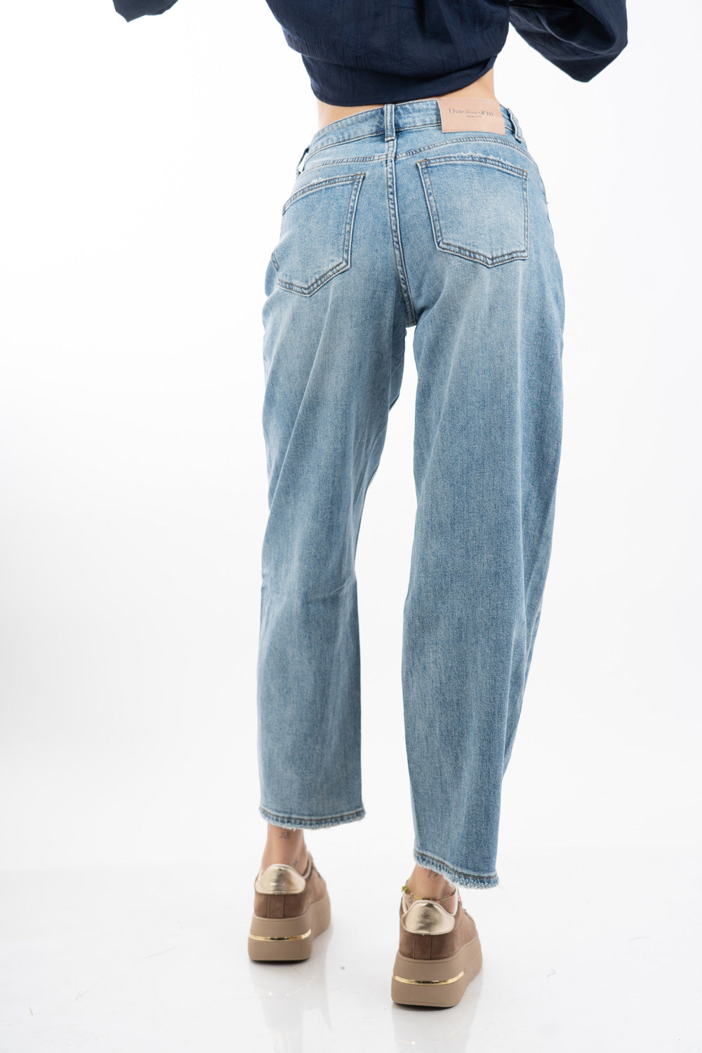 modella indossando Jeans balloon in denim elasticizzato con fondo taglio vivo colore