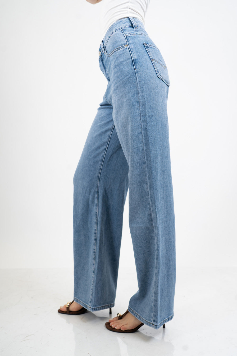 Jeans palazzo a vita bassa in denim lavaggio medio con gamba ampia.