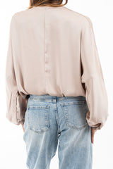 modella indossando Blusa in raso fluido con scollatura incrociata e maniche a palloncino colore