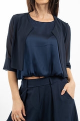 modella indossando Bolerino corto in georgette velata con manica 3/4 colore Blu Unica