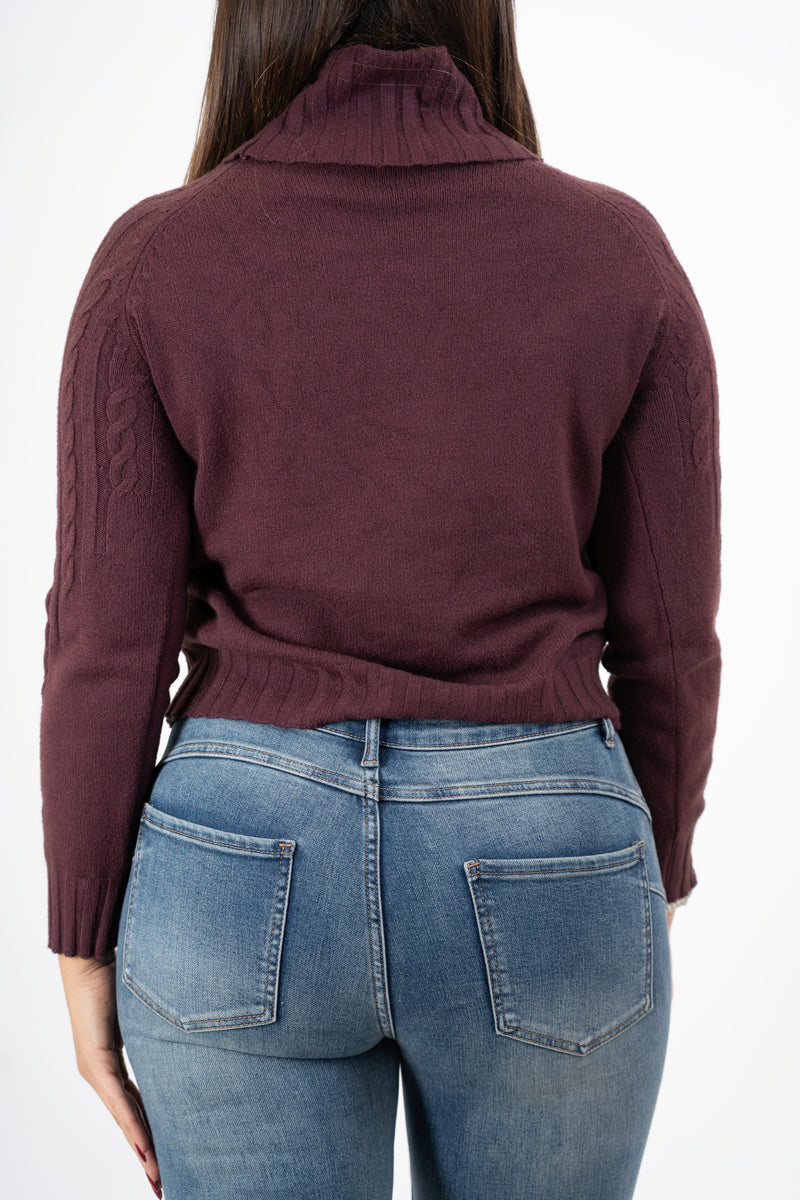 modella indossando Dolcevita CozyCable spalle treccia colore