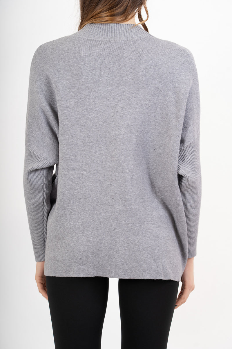 modella indossando Maglia over corta in filato caldo con maniche a costine e collo alto colore