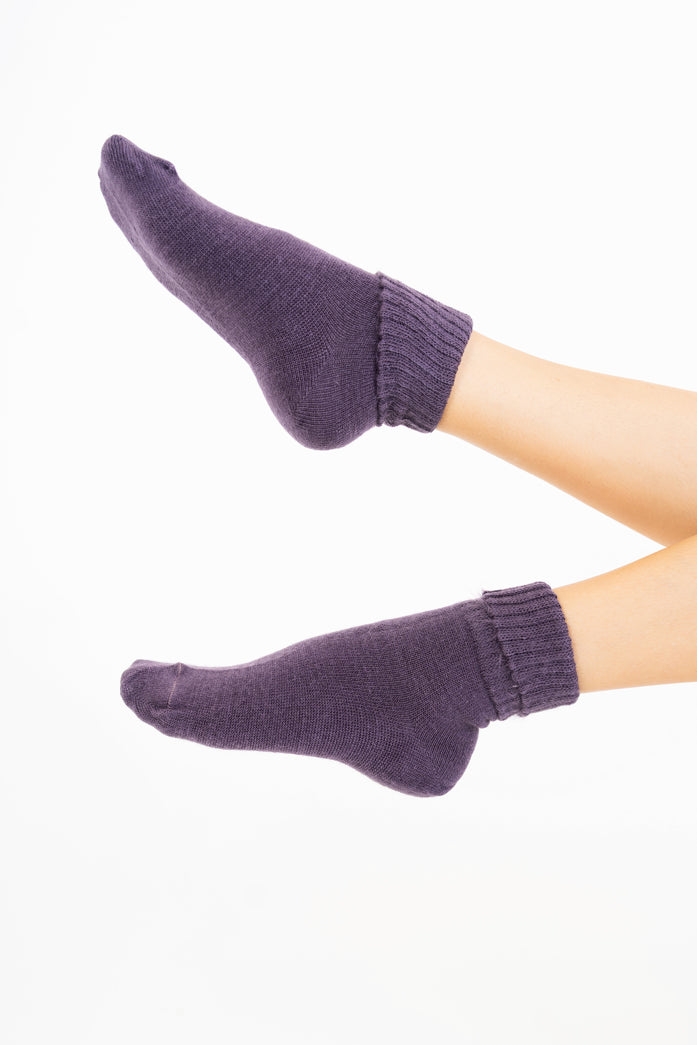 modella indossando Calze corte “Carezza” in filato morbido con bordo risvoltato colore Melanzana Unica