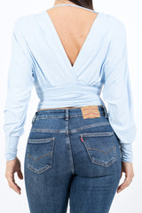 modella indossando Maglia crop drappeggiata con doppio scollo incrociato e spalle strutturate colore