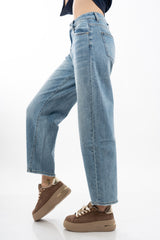 modella indossando Jeans balloon in denim elasticizzato con fondo taglio vivo colore