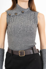 modella indossando Maglia smanicata a trecce con collo alto e bottoni laterali colore Grigio Unica