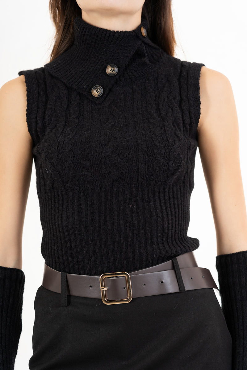 modella indossando Maglia smanicata a trecce con collo alto e bottoni laterali colore Nero Unica