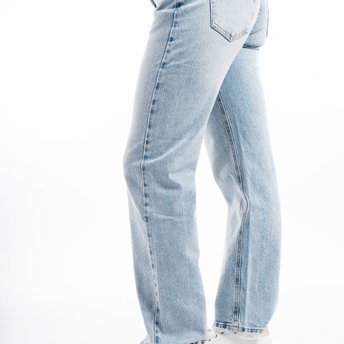 modella indossando Jeans donna straight a vita media in denim morbido con fondo sfrangiato colore Denim Medio