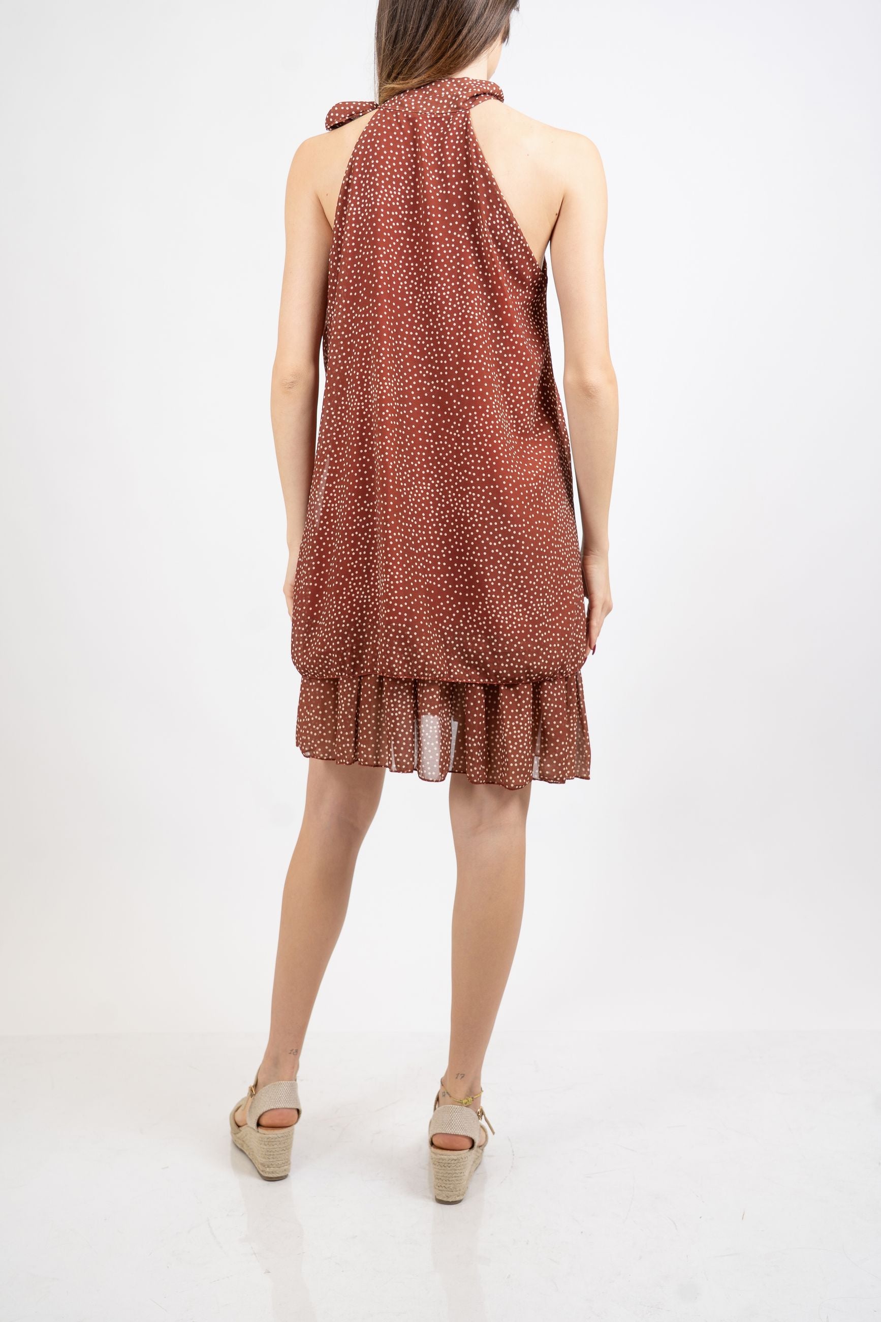 Abito pois con scollo all’americana e balze.