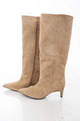 modella indossando Stivali Beige al ginocchio effetto camoscio con tacco medio e punta affusolata colore sabbia