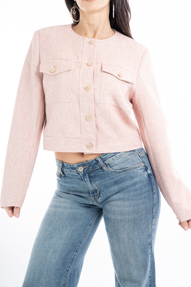 modella indossando Giacchina corta strutturata effetto tweed rosa con bottoni gioiello colore Rosa