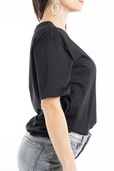 modella indossando T-shirt scritta “Se parli male di me ti prego esagera” colore